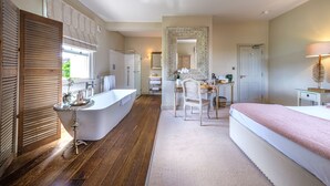 Een moderne badkamer met een vrijstaand bad, een wastafel met spiegel en een douche.