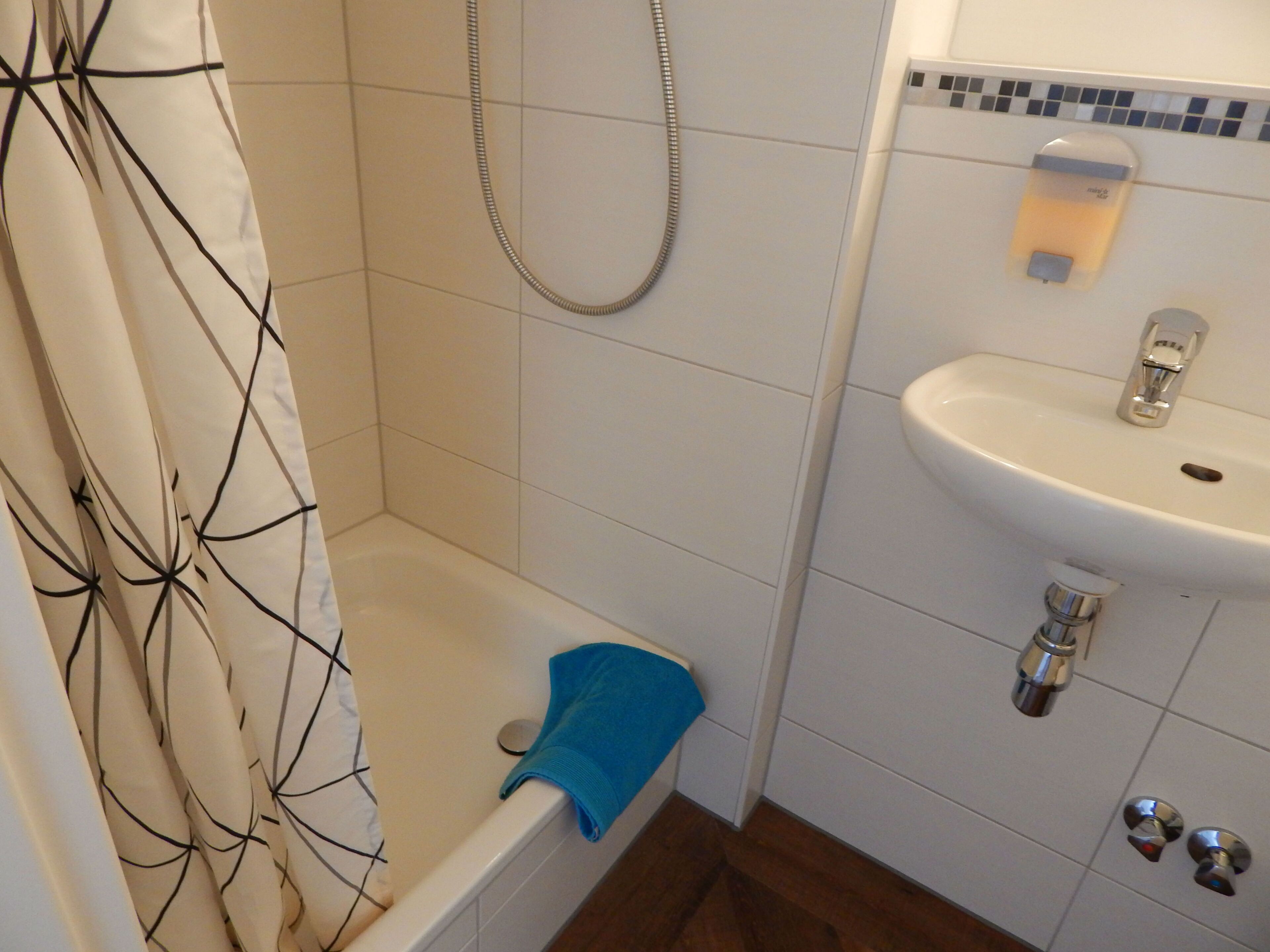 Un baño con bañera, ducha y lavabo.