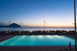 A swimming pool with a view of the sea and a mountain at sunset. - Camping Village El-Bahira (San Vito Lo Capo)