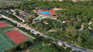 Vista aérea de uma área residencial com casas, quadra de tênis e piscina.
