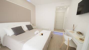 Una habitación de hotel moderna con una cama grande, una mesita de noche y un televisor montado en la pared.