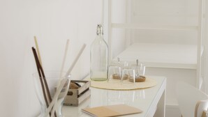 A white table with a glass bottle, a notebook, and a wooden box. - B&B Chérie - Centro di Salerno (Salerno)
