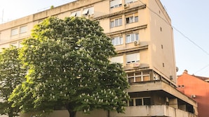 A multi-story building with a large tree in front, a parking sign, and a street view. - The Harmony Rooms Split (Split)