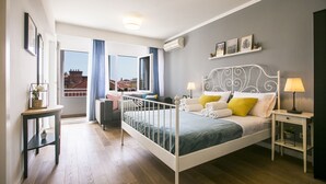 A modern bedroom with a bed, bedside tables, a desk, and a window with curtains. - The Harmony Rooms Split (Split)