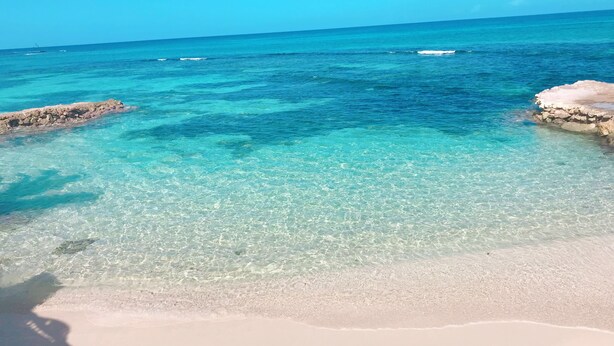 Una vista despejada de una playa con aguas turquesas y una orilla arenosa.