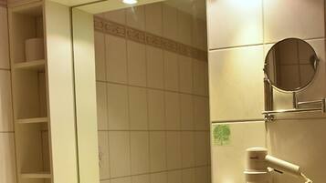 A bathroom with a sink, mirror, and towel rack.