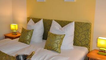 A hotel room with a large bed, two bedside tables with lamps, and artwork on the wall.