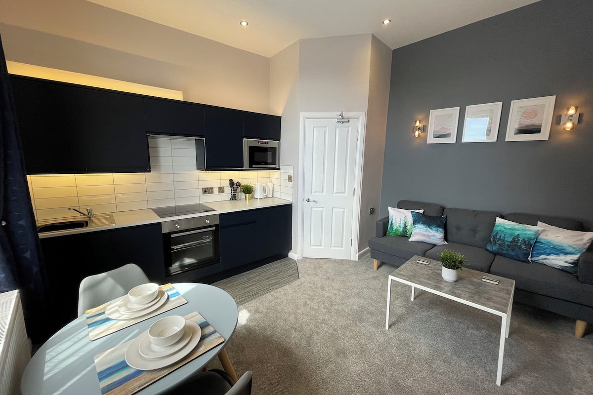 A compact living space with a kitchenette, a dining area, and a seating area.