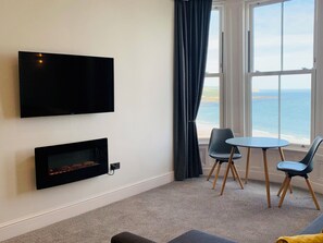 Appartement Deluxe, 1 chambre, non-fumeurs, vue mer (First Floor) | Coin séjour | Télévision LCD de 40 pouces avec chaînes numériques, cheminée, Netflix