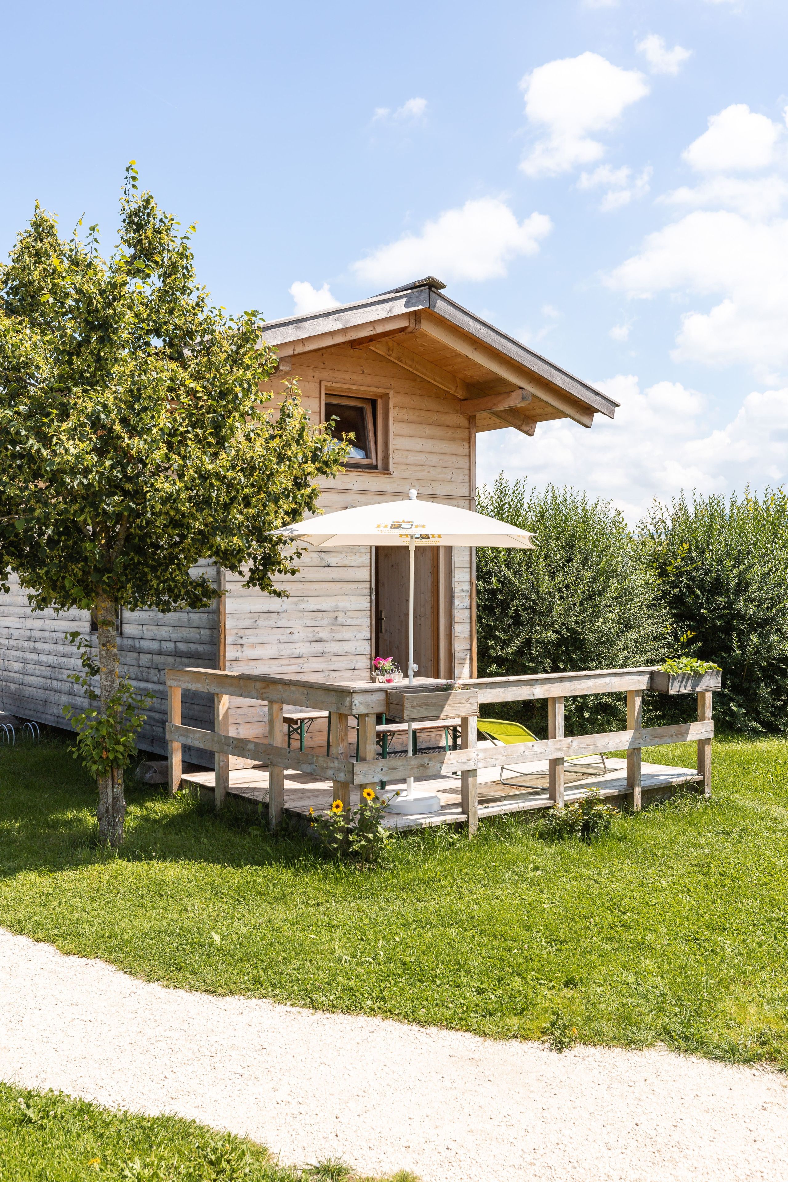 Eine Holzhütte mit einer kleinen Veranda und einem Tisch mit einer Bank.