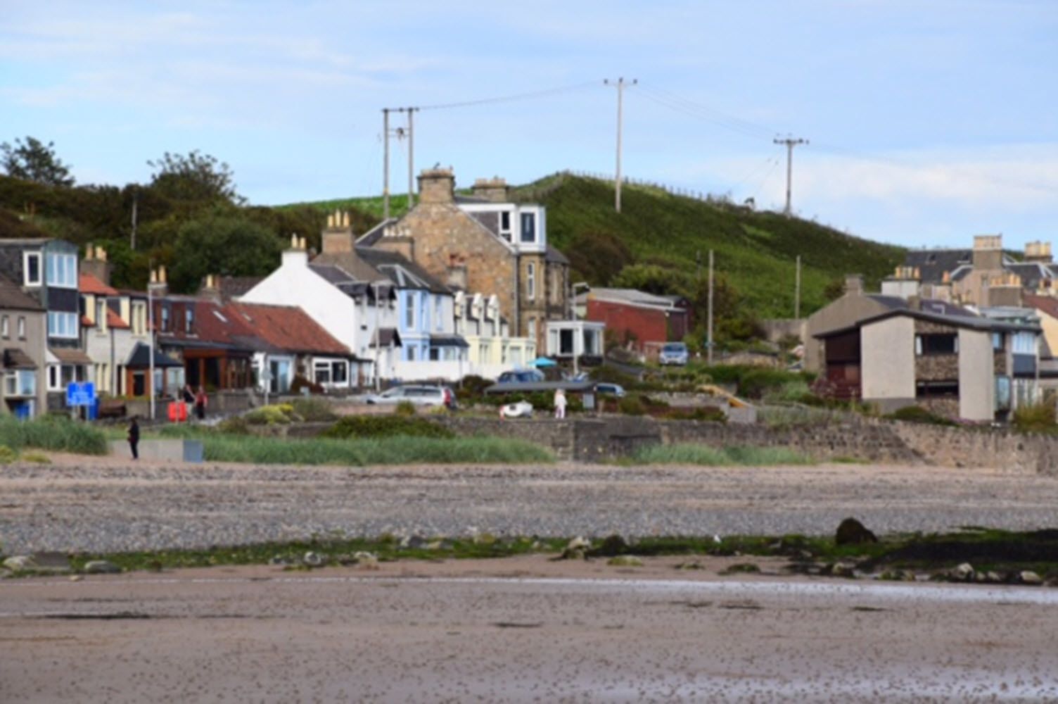 A coastal town with a mix of residential buildings, including houses and a small shop.