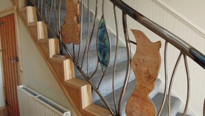 Eine Holztreppe mit Metallgeländern und einem Heizkörper am Fuß.