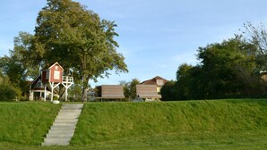 A residential area with a staircase leading to a house with a red exterior and a white porch.
