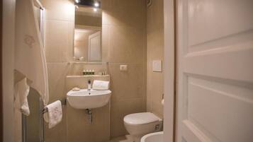 Un bagno con lavandino, WC e doccia.