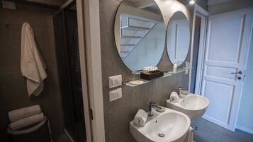 A bathroom with two sinks, a mirror, and a towel rack.