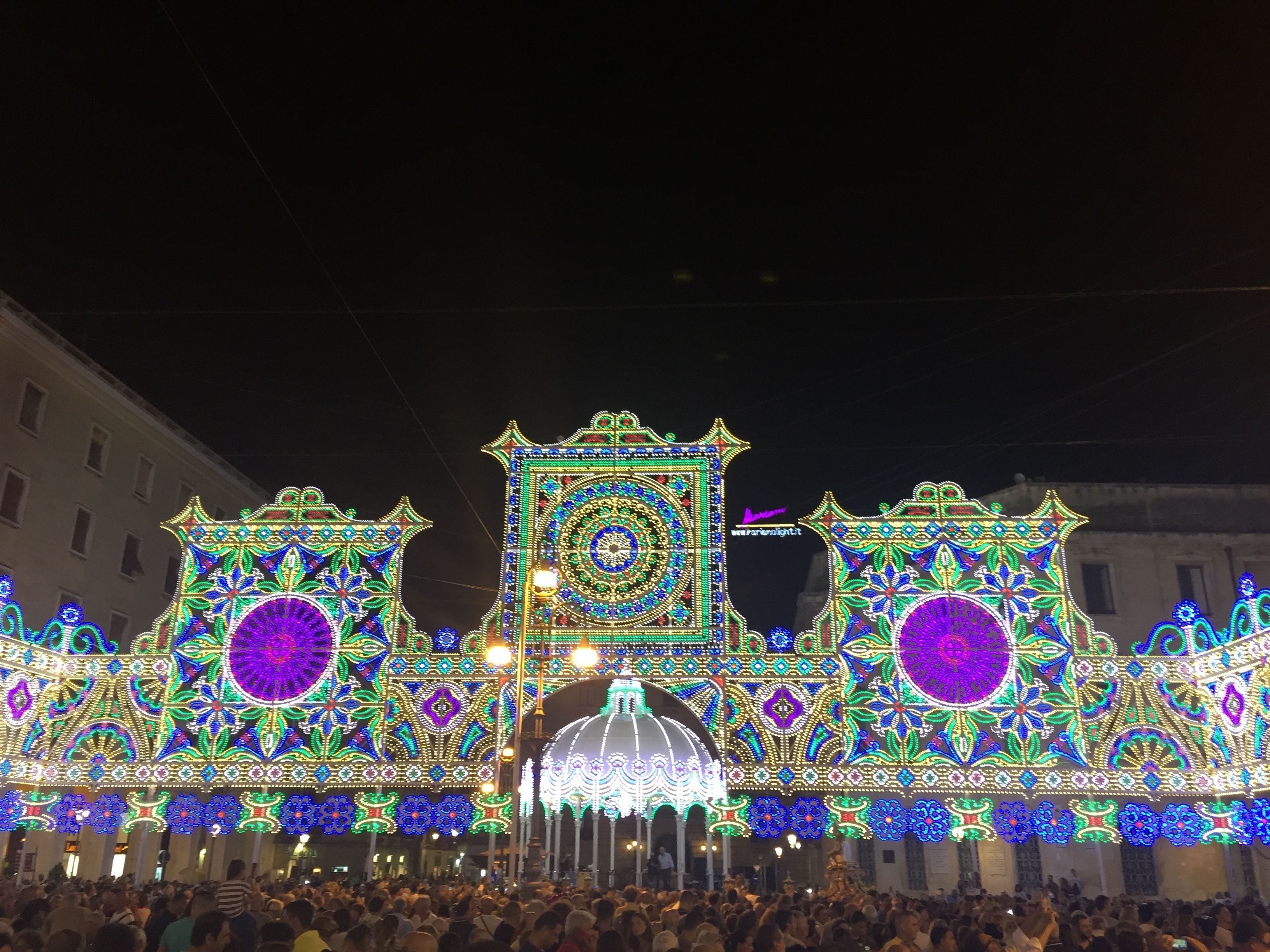 Une foule nombreuse s’est rassemblée devant un bâtiment dont l’architecture était richement décorée et illuminée.