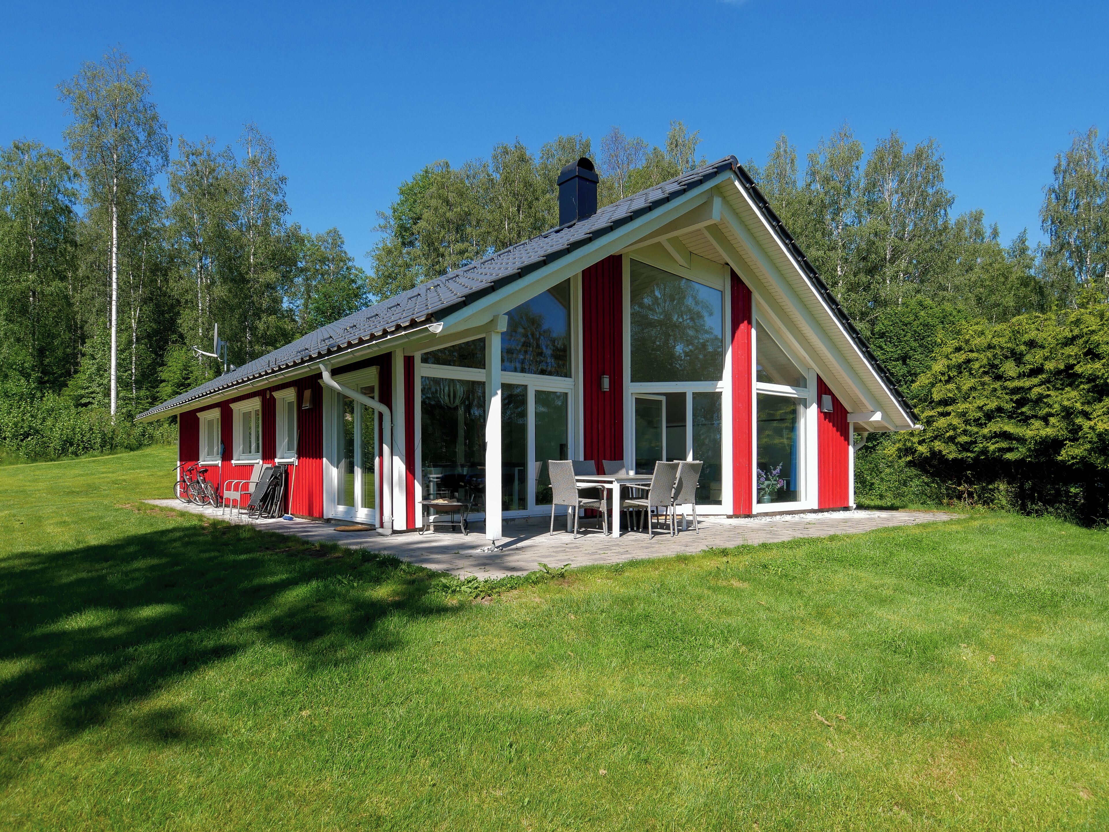 A red and white house with a covered patio and a large window.
