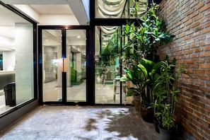 Relax in a stylish space with a seating area, potted plants, and a brick accent wall.