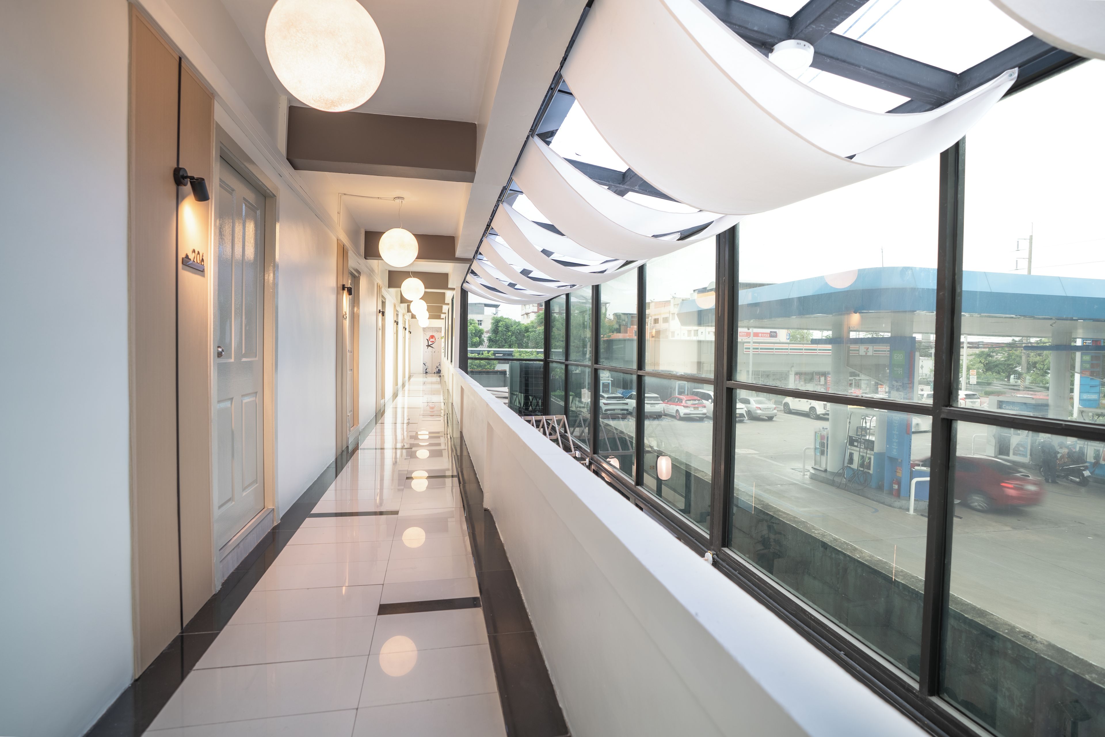 A corridor with a view of a parking lot through large windows.