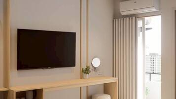 A modern hotel room with a flat-screen TV mounted on a wooden shelf, a small bedside table with a lamp, a bedside plant, and a large window with curtains.
