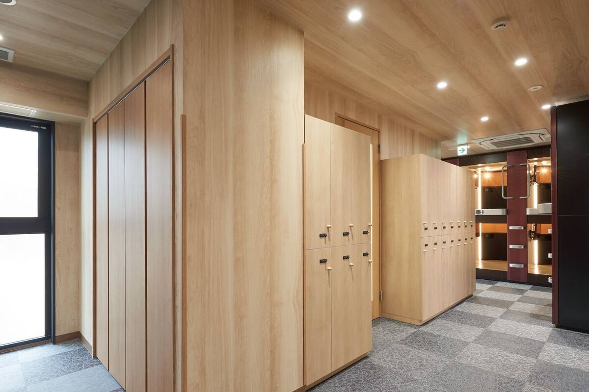 Un pasillo con taquillas de madera y suelo a cuadros.