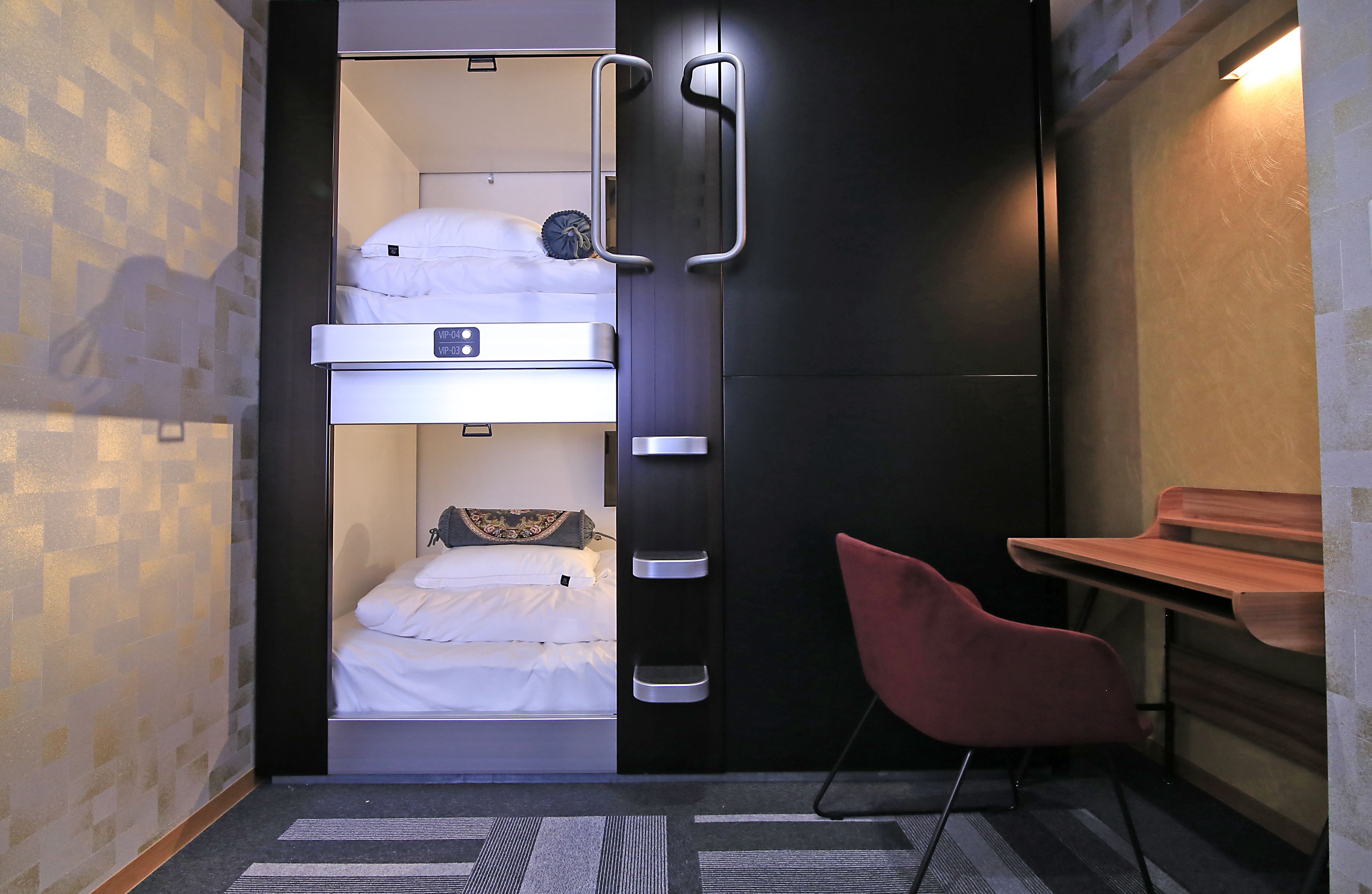 A compact room with a bunk bed, a desk, and a chair.