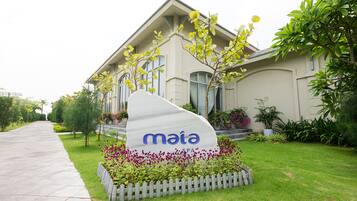 A spa sign in front of a building with a well-maintained lawn and a picket fence.