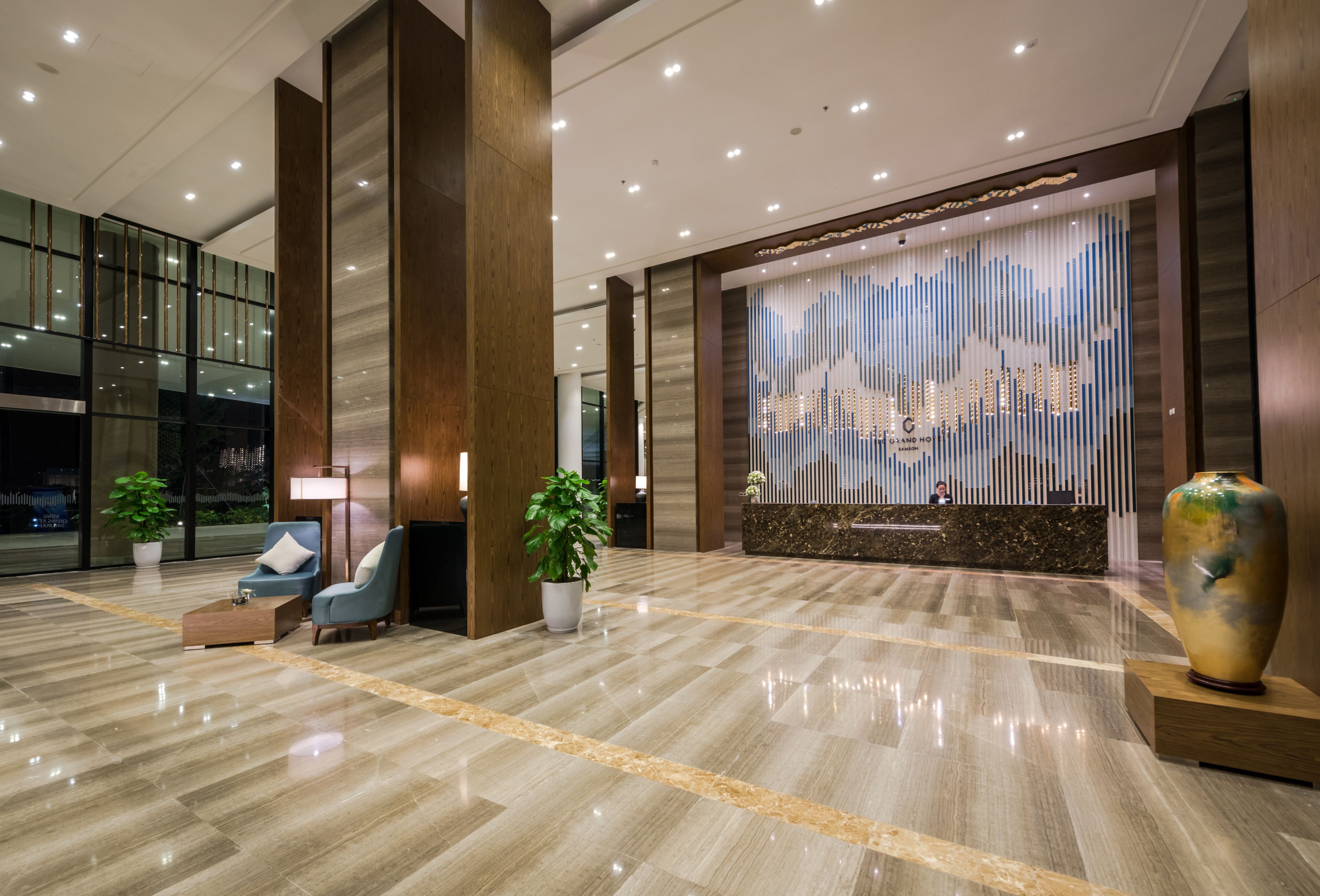Eine moderne Lobby mit Empfangstresen, Sitzgelegenheiten und Dekorationselementen.
