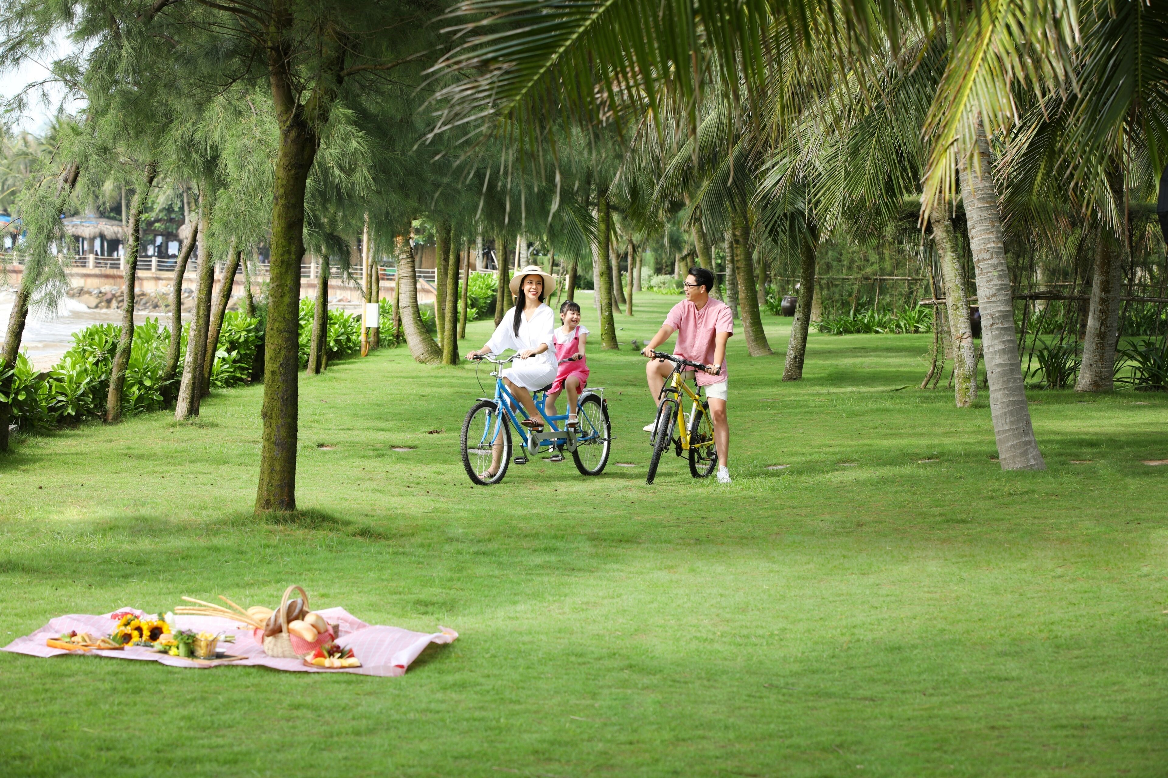 Una familia en bicicleta en un parque, con una preparación para picnic.