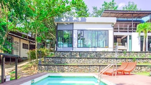 A swimming pool with lounge chairs, a stone wall, and a building with large windows and a sign reading "HOW DO YOU FEEL TODAY". - Nana River Kaeng Krachan (Kaeng Krachan)