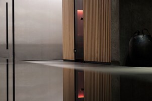Ένας μοντέρνος εσωτερικός χώρος με ένα γυαλιστερό δάπεδο, τοίχους επενδυμένους με ξύλινα πάνελ και μια μεγάλη μαύρη τσάντα.
