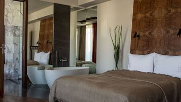 A modern bedroom with a large bed, a built-in bathtub, and a mirror.
