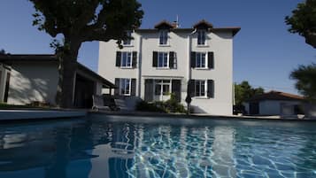 Una piscina al aire libre de temporada, sombrillas