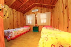 A wooden cabin room with two beds, a ceiling fan, and a small table. - Olympos Ruya Pansiyon (Kumluca)