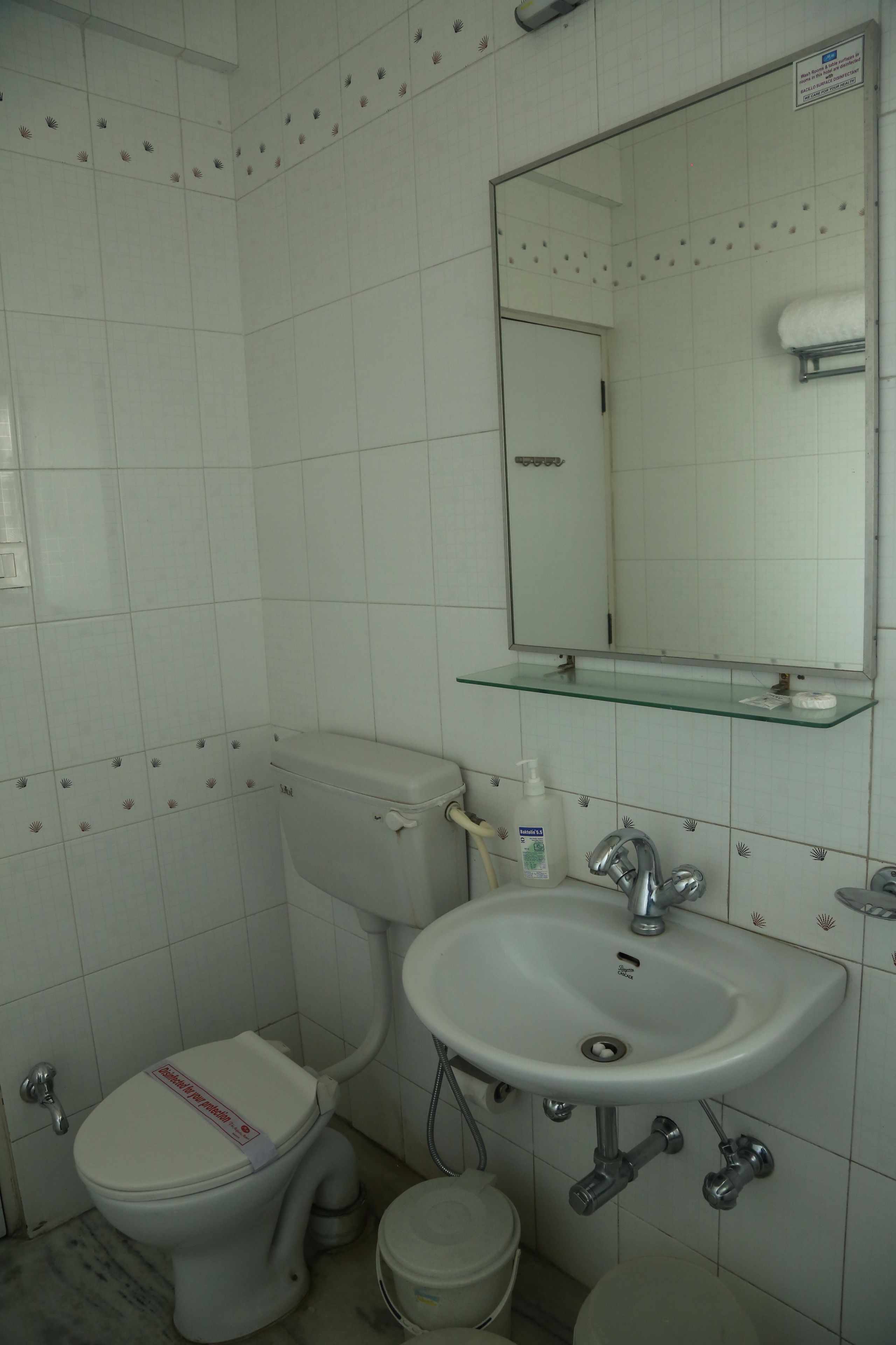 Ein Badezimmer mit Toilette, Waschbecken und Spiegel.