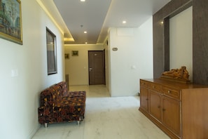 A hallway with a sofa, a cabinet, and a door.