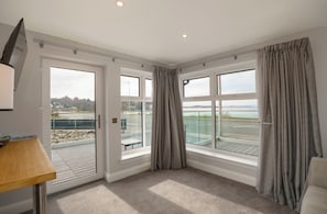 Escritorio, cortinas blackout y tabla de planchar con plancha