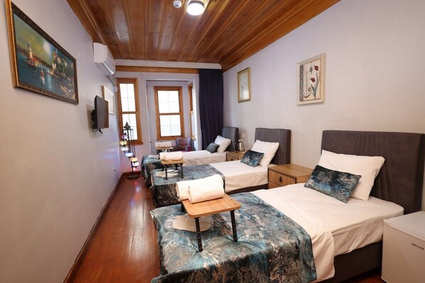 Ein Hotelzimmer mit zwei Betten, einer Holzbalkendecke und einem Bild an der Wand.