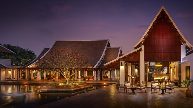 A traditional building with a large red roof and a courtyard with seating and a small water feature. - Sabai Sabai Sukhothai (Sawankhalok)