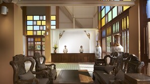 A traditional room with wooden furniture, a central seating area, and large windows with decorative panes. - Sabai Sabai Sukhothai (Sawankhalok)