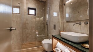 A modern bathroom with a glass-enclosed shower, a white toilet, and a large sink with a mirror above it. - Alektor Studios & Apartments (Zakynthos)