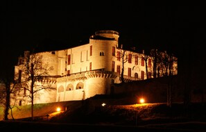 A historic building with a round tower, arched windows, and a balcony.