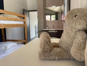 A bunk bed with a white mattress and a teddy bear sitting on a table. - Charming 3BR Beach House with Garden, Terrace & Parking - Steps from Noirmoutier-en-l'Île Beach (Noirmoutier-en-l'Île)
