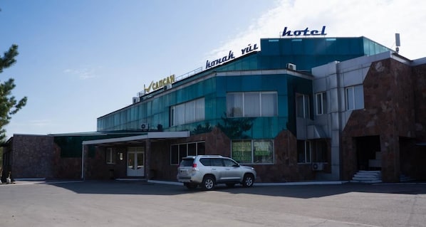 A hotel with a modern design, featuring a large glass facade and a stone exterior.