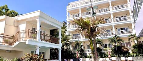 A hotel with a swimming pool, multiple balconies, and outdoor seating areas.