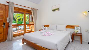 Un dormitorio con una cama de madera, una mesita de noche, una lámpara de pared y una ventana con cortinas.