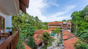 Un patio con varios edificios, una piscina y abundante vegetación.