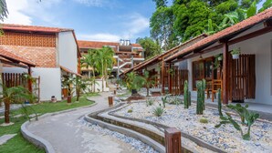 Un patio con un sendero central, rodeado de edificios con techos de tejas y balcones de madera.