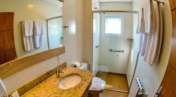 A bathroom with a granite sink, a mirror, a toilet, and a shower. - Pousada Aconchego da Borges (Gramado)