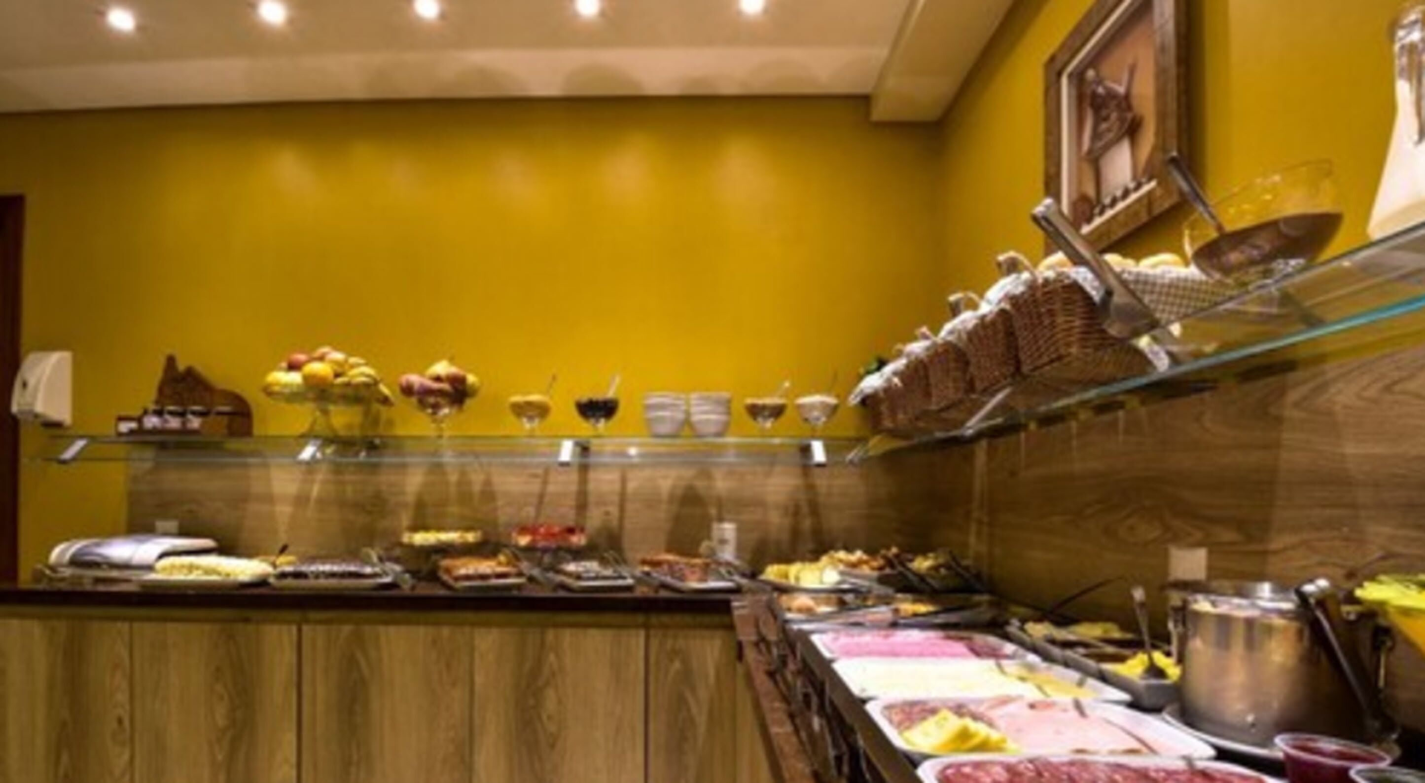 A buffet area with various food items and condiments.